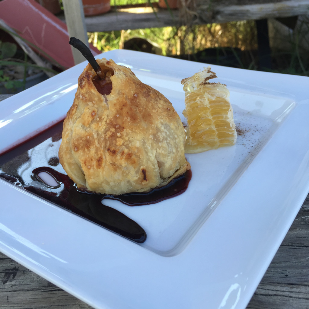 Pear poached in red wine stuffed with Drake farm apricot goat cheese wrapped in pastry served with red wine syrup and chai dusted honeycomb